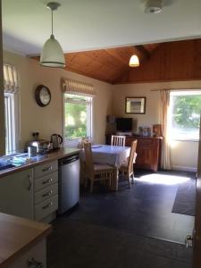 eine Küche und ein Esszimmer mit einem Tisch und Stühlen in der Unterkunft Creity Hall Chalet in Stirling