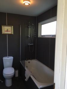 ein Badezimmer mit einer Badewanne, einem WC und einem Waschbecken in der Unterkunft Creity Hall Chalet in Stirling