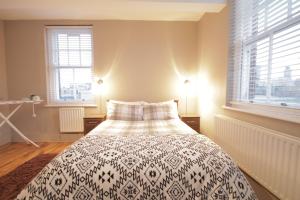 ロンドンにあるHenley at Shoreditchのベッドルーム1室(ベッド1台、白黒の毛布付)