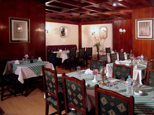a dining room with two tables and chairs with tablesearcher at Hotel Concorde Dokki in Cairo