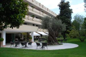 una mesa y sillas frente a un edificio en Ermitage Bel Air Medical Hotel en Abano Terme