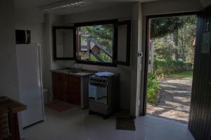 uma cozinha com um fogão e uma porta para um quintal em Chalés entre Nuvens e Estrelas em Monte Verde mais 16 fotografias