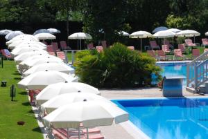 a row of white umbrellas next to a swimming pool at Ermitage Bel Air Medical Hotel in Abano Terme