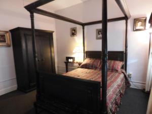 a bedroom with a four poster bed in a room at Cassadaga Hotel and Spiritual Center in Cassadaga