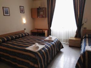 Postel nebo postele na pokoji v ubytování Hotel Loreto