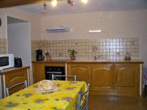 cocina con mesa y mantel amarillo en Gite De La Tour De Rouilleres, en Ambierle