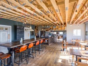 a restaurant with a bar with chairs and tables at The Sail Loft in Southwold +30 photos