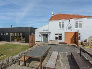 a building with a picnic table in front of it at The Sail Loft in Southwold