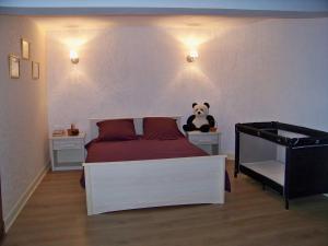 a bedroom with a panda bear sitting on a bed at Gite De La Tour De Rouilleres in Ambierle