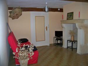 アンビエルルにあるGite De La Tour De Rouilleresのリビングルーム(赤いソファ、暖炉付)