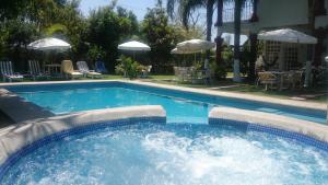 a swimming pool with chairs and tables and umbrellas at Quinta Belu Oaxtepec in Oaxtepec