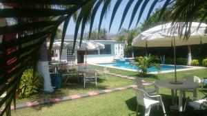a patio with a table and chairs and a pool at Quinta Belu Oaxtepec in Oaxtepec