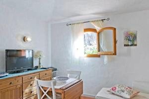 ポルト・チェルボにあるTeresa Holiday Homeのテレビとテーブルと椅子のあるリビングルーム