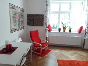 布拉格的住宿－Garden Apartment，客厅配有红色椅子和桌子