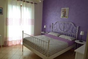 a bedroom with a bed with purple walls at Good Morning Etna in Bronte