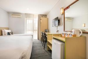 a hotel room with a bed and a desk and a kitchen at Nightcap at Coolaroo Hotel in Coolaroo