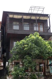 un edificio de apartamentos con un árbol delante de él en Guest House Fotini 2 en Sozopol