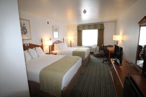a hotel room with two beds and a television at Best Western Liberty Inn in Delano