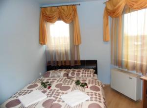 ハイドゥソボスローにあるÉden apartmanのベッドルーム1室(花の飾られたベッド1台付)