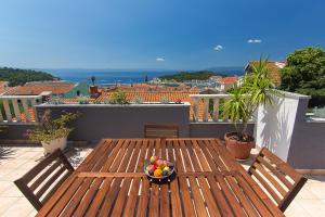 un plato de fruta en una mesa de madera en un balcón en Villa Mađor, en Makarska