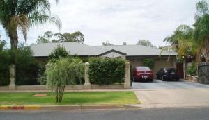 a house with two cars parked in a driveway at A Good Rest B & B in Alice Springs