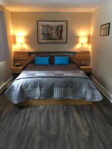 a bedroom with a large bed with blue pillows at Auberge De Mon Petit Chum B&B in Wakefield