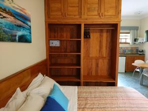 um quarto com uma cama, um armário e uma cozinha em Galápagos ApartHotel em Ilhabela