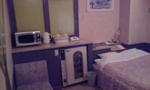 una camera d'albergo con un letto e un forno a microonde su un bancone di Hotel Ikoma (Love Hotel) a Nagasaki