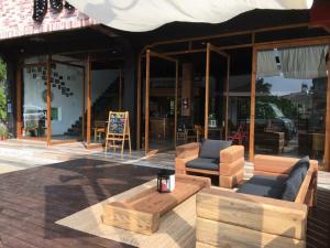 a patio with a table and chairs and a building at perBed Hostel-Sun Moon Lake Station in Yuchi