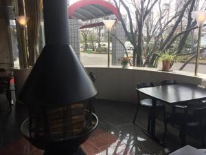 una chimenea en un restaurante con mesa y sillas en Hotel 21, en Kusatsu