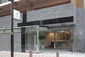 una fachada de un edificio con una puerta de cristal en SARASA HOTEL Shinsaibashi, en Osaka