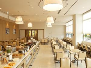 una grande sala da pranzo con tavoli e sedie di Hotel Sunroute Sopra Kobe Annesso a Kobe
