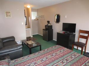 a hotel room with a bed and a couch and a television at Overlander Motel in Chase