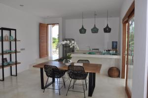 een keuken met een houten tafel en stoelen bij Villa Enjoy in Canggu