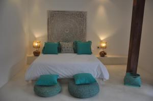 een slaapkamer met een bed met twee groene kussens en twee lampen bij Villa Enjoy in Canggu