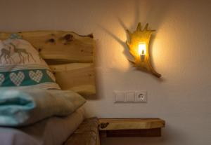 ein Schlafzimmer mit einem Bett und einer Lampe an der Wand in der Unterkunft Troadkasten in Kötschach