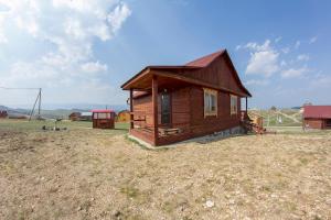 a small wooden cabin in a field with a field at Azatey Guest House in Sakhyurta