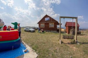 a group of people playing on a playground with a house at Azatey Guest House in Sakhyurta