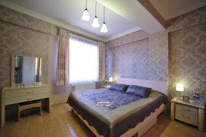 a bedroom with a bed and a dresser and a mirror at Tanan Center Serviced Apartments in Ulaanbaatar