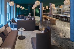 a lobby with couches and tables and a bar at Zander K Hotel in Bergen