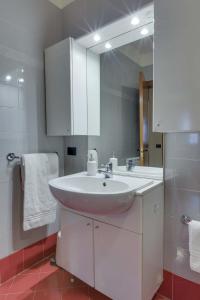 een badkamer met een witte wastafel en een spiegel bij Quartiere Padova 2000 in Padua