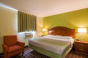 a hotel room with a bed and a chair at Savannah Garden Inn in Savannah