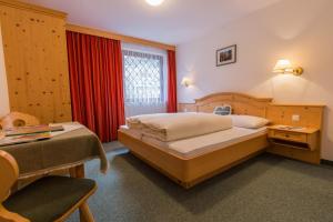 a bedroom with a bed and a desk and a chair at Alpengasthaus Gleinserhof in Schönberg im Stubaital