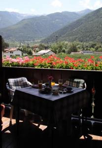 uma mesa numa varanda com vista para as flores em Pension Tannenhof em Laces