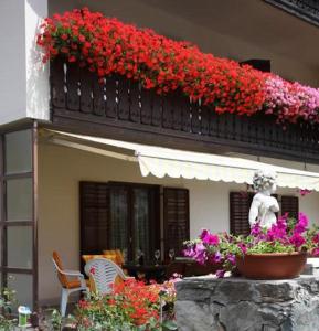 a balcony with a bunch of flowers on a building at Pension Tannenhof in Laces