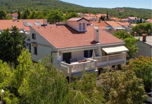 a large white house with a balcony in a town at Villa Punta in Punat