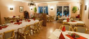 トルガウにあるHotel Torgauer Brauhofの白いテーブルと赤いナプキンの椅子が備わるレストラン