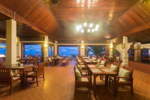 a restaurant with wooden tables and chairs and windows at Samui Buri Beach Resort in Mae Nam