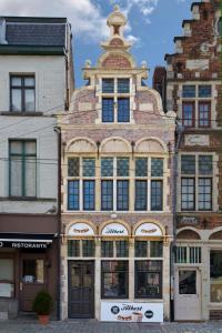 un grand bâtiment en briques avec une tour en haut dans l'établissement De Waterzooi Lodge, à Gand