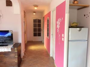 pasillo con paredes de color rosa y blanco y nevera en Les Hauts du Baousset, en Menton
